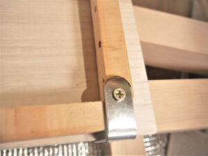 L字金具で取りつけたダイソーまな板と木枠の裏面